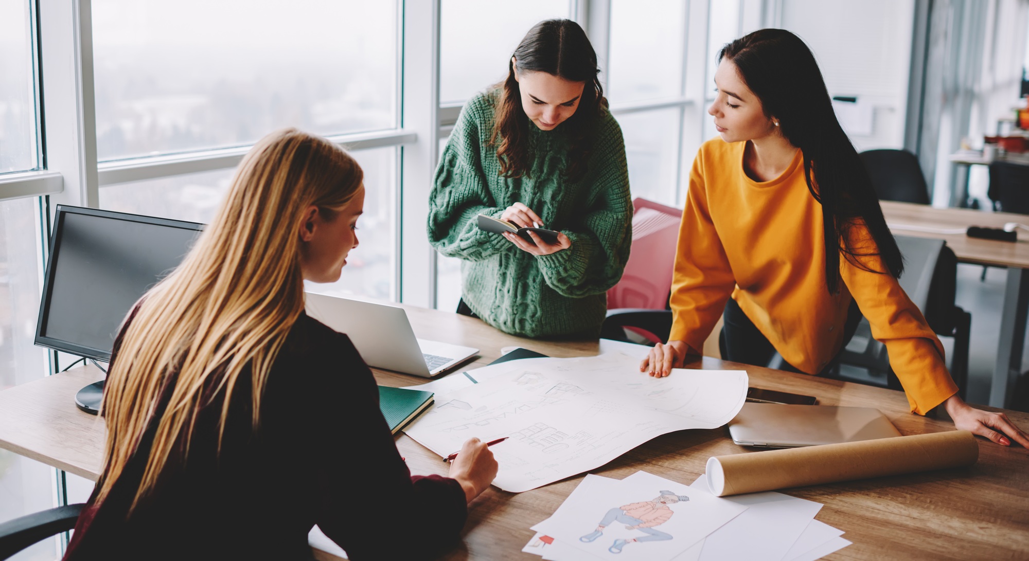 Women with sketches on paper working together